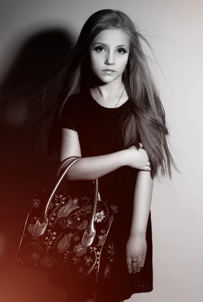 Mode kleines Mädchen mit Tasche posiert im Studio — Stockfoto