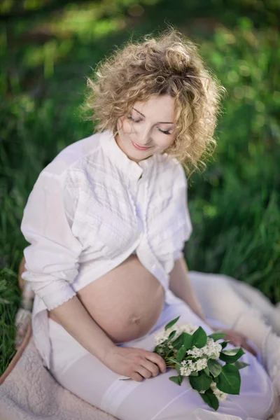 Beautiful pregnant woman in blooming garden — Stock Photo, Image