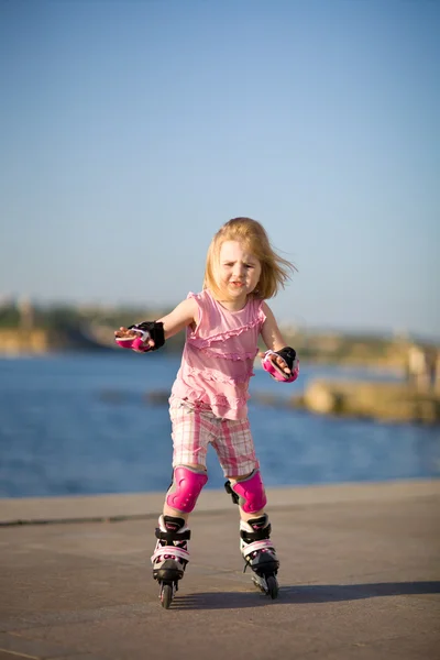 stock image Young pretty girl on rollerskates in the park