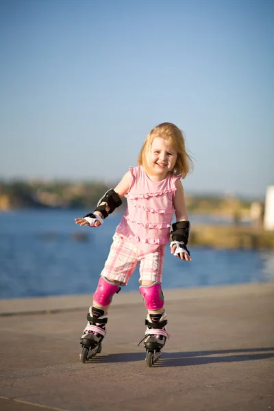 stock image Young pretty girl on rollerskates in the park