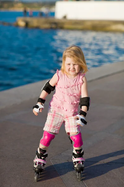 年轻漂亮的女孩在公园内的滚轴溜冰鞋 — 图库照片