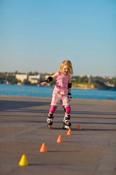 Jovem menina bonita em patins no parque — Fotografia de Stock