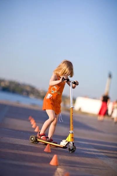Menina bonita montando uma scooter — Fotografia de Stock