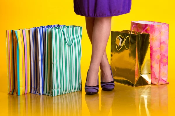 Pernas femininas e sacos de compras — Fotografia de Stock