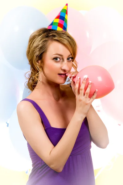 Menina encantadora soprando um balão rosa — Fotografia de Stock