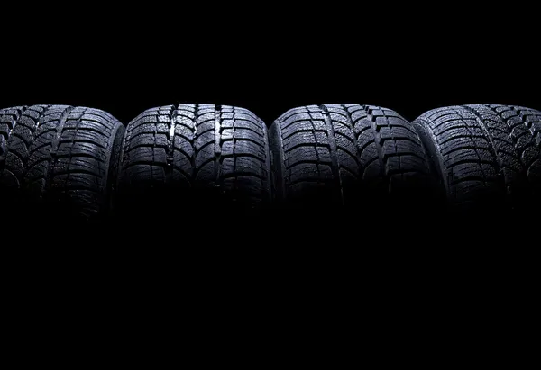 Auta pneumatiky izolované na černém pozadí — Stock fotografie