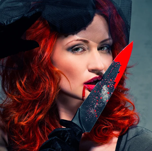 Wspaniała ruda kobieta z zakrwawionym nożem w ręku zbliżenie — Zdjęcie stockowe