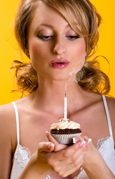 Mulher bonita soprando velas no aniversário cupcake — Fotografia de Stock