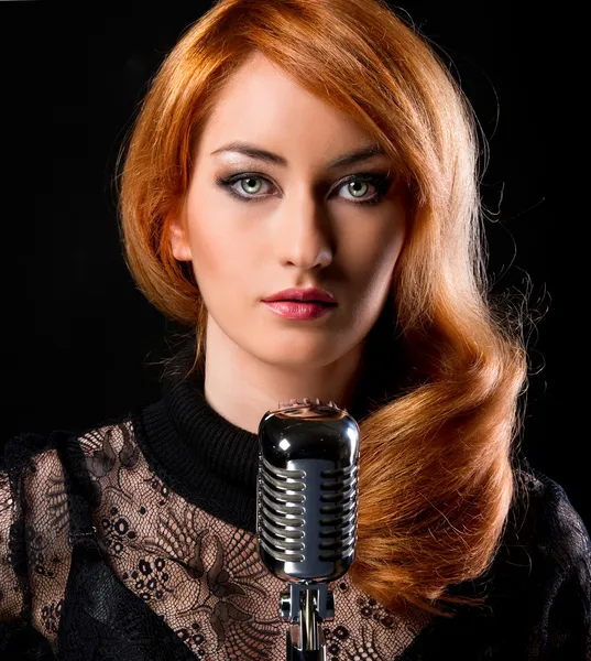 Шикарная стильная рыжая женщина с ретро-микрофоном — стоковое фото
