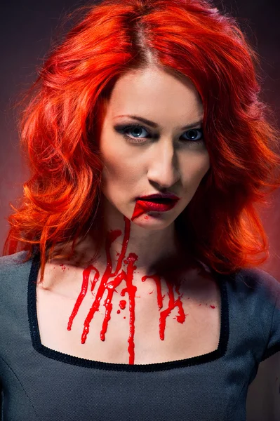 Retrato de uma mulher ruiva com sangue nos lábios e pescoço — Fotografia de Stock