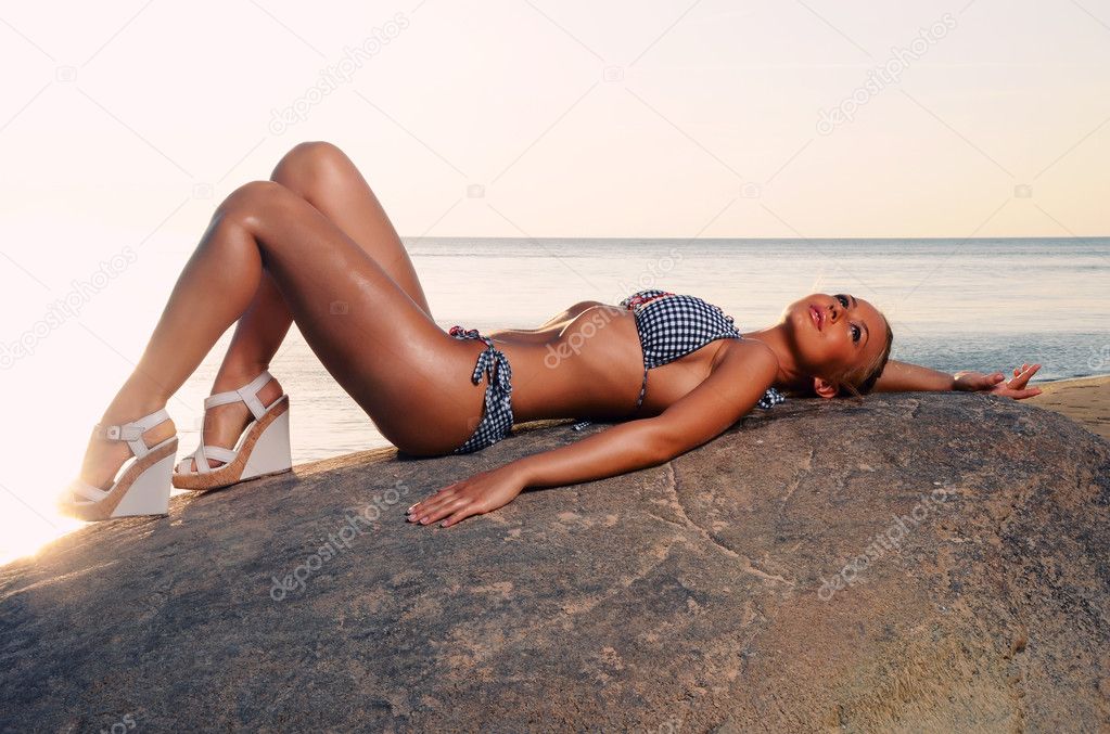 Beautiful young woman relaxing on the beach near the sea