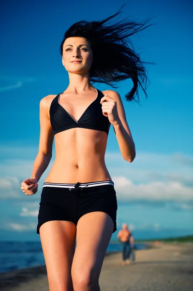 Vrouw loopt op het strand — Stockfoto