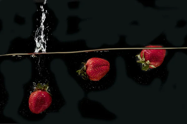Jordgubbar i vatten — Stockfoto