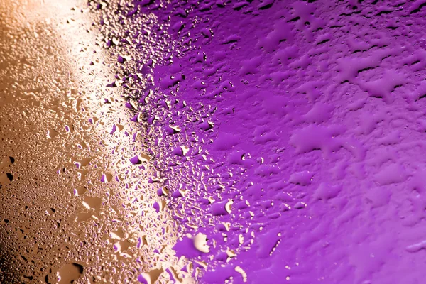 Vattendroppar på golden och lila — Stockfoto