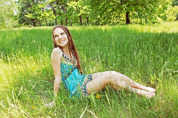 Dziewczyna siedzi na polanie — Zdjęcie stockowe