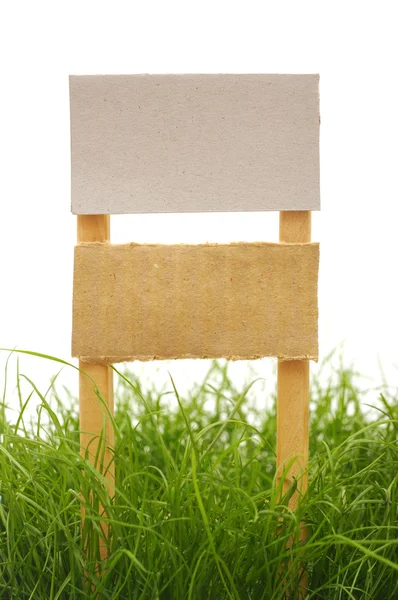Sinal de papelão com grama isolada em um fundo branco — Fotografia de Stock