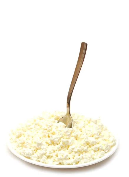Heap of cottage cheese and spoon in white plate — Stock Photo, Image
