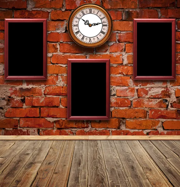 Leere Fotorahmen und Uhr gegen Ziegelwand in altem Raum — Stockfoto
