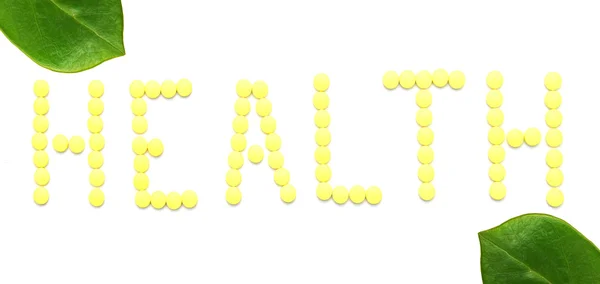 Palavra SAÚDE feita a partir de pílulas de medicação amarela isoladas em branco — Fotografia de Stock