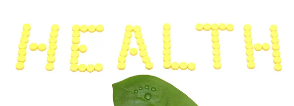 Palavra SAÚDE feita a partir de pílulas de medicação amarela isoladas em branco — Fotografia de Stock