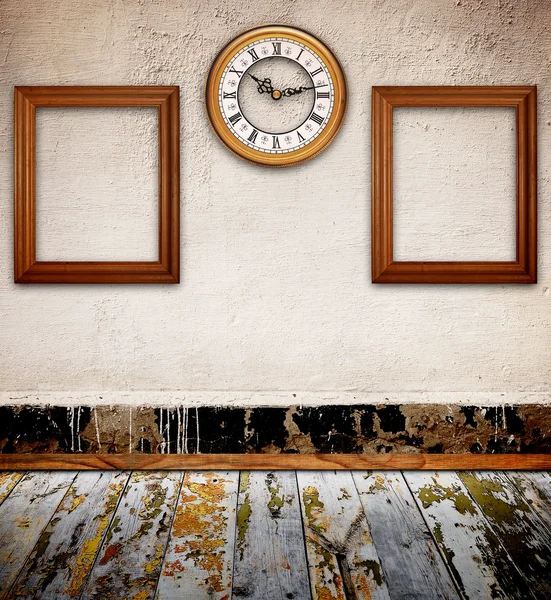 Empty photo frames and watch against an wall in old room — Stock Photo, Image