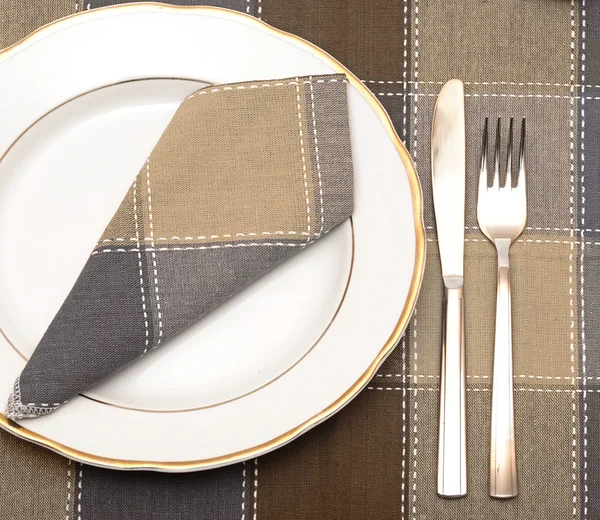 Μαχαίρι και πιρούνι με λευκό πιάτο στο ξύλινο τραπέζι — Φωτογραφία Αρχείου