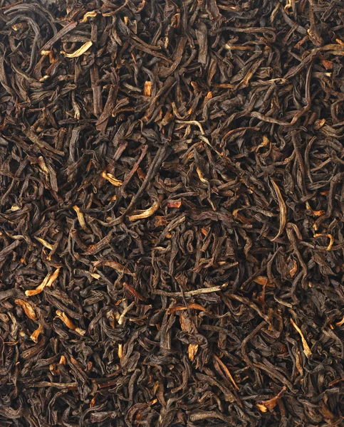 Manciata di foglie di tè nero su sfondo bianco — Foto Stock