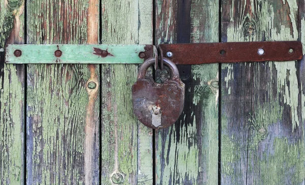 Paslı kilit ile eski ahşap kapılar kilitli — Stok fotoğraf