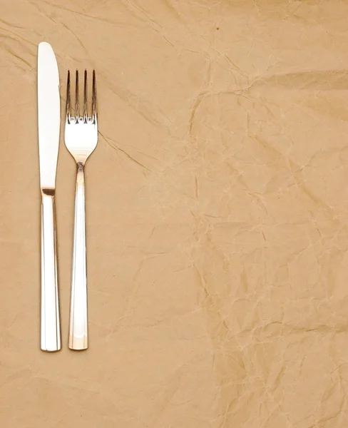Cuchillo y tenedor sobre papel viejo. espacio para el texto — Foto de Stock