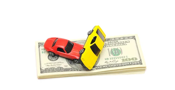 Unfall mit Spielzeugauto wegen vieler Dollarscheine auf weißem Grund — Stockfoto