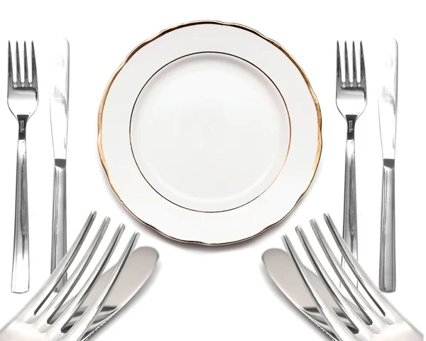 Kniv, vit platta och gaffel på vit bakgrund — Stockfoto