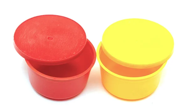 Желтая и красная пластиковая банка на белом — стоковое фото