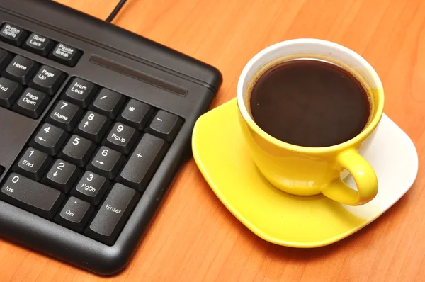 Černá klávesnice a šálek kávy — Stock fotografie