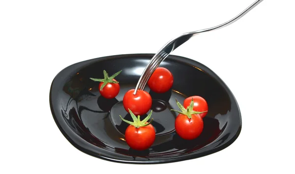 Pomidory na czarnej płycie — Zdjęcie stockowe