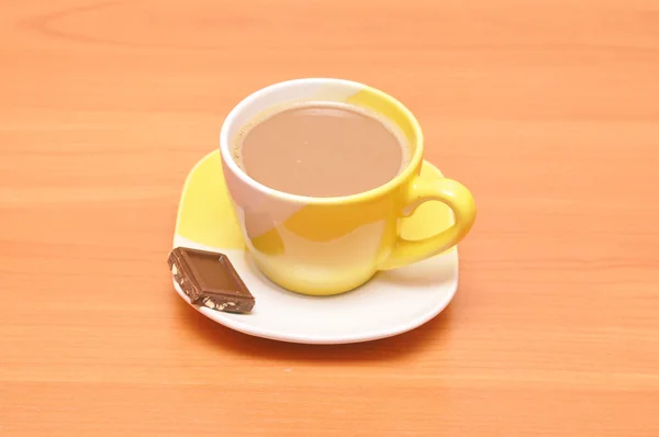 Yellow hot coffee cup with chocolate — Stock Photo, Image
