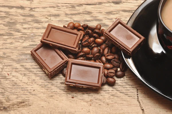 Närbild av nyberedd kopp kaffe med bönor och choklad — Stockfoto