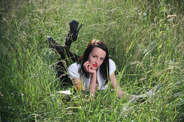 Chica en la hierba, con libros . — Foto de Stock