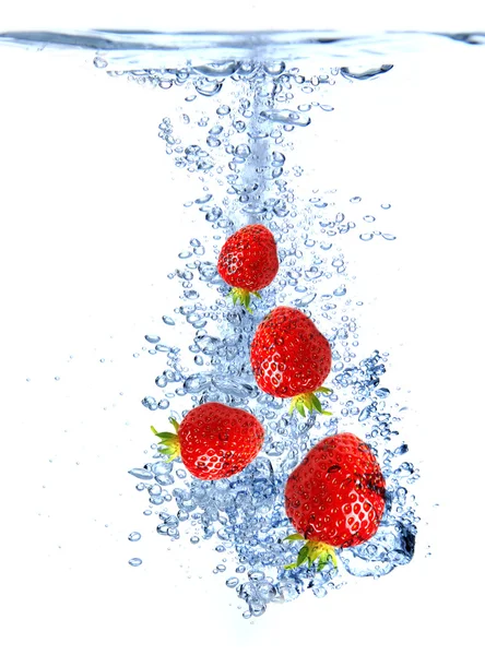 Fruit splashing into the water — Stock Photo, Image