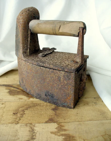 stock image The old iron on a wooden table