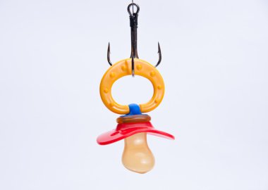 Infant pacifier hangs on a hook clipart