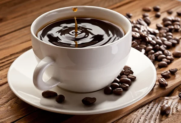 Tropfen fallen in eine Tasse Kaffee — Stockfoto