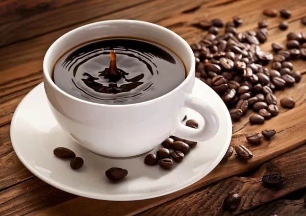 Tropfen fallen in eine Tasse Kaffee. — Stockfoto