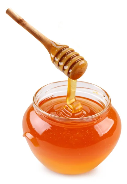 Hrnec medu a dřevěnou tyčí. — Stock fotografie