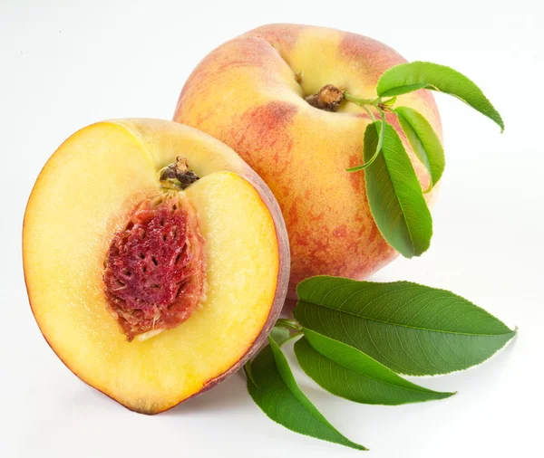 Fruta de pêssego madura com folhas e lascas — Fotografia de Stock
