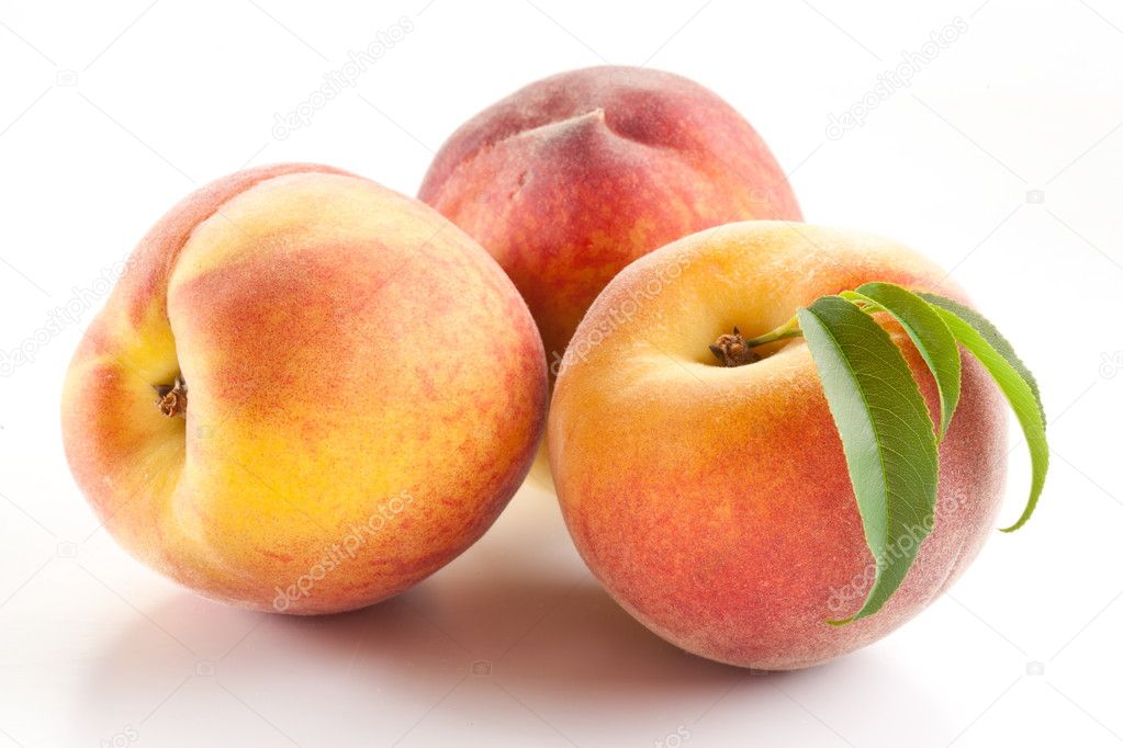 Three ripe peach with leaves