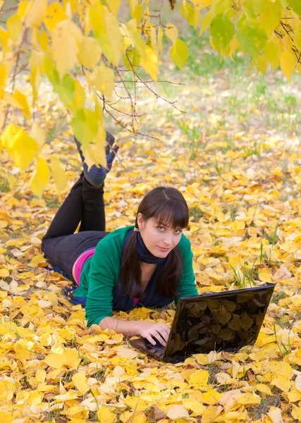 Красивая девушка отдыхает на осенних листьях — стоковое фото