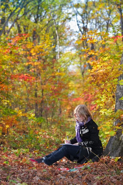 Активная симпатичная девушка сидит на дереве в парке — стоковое фото