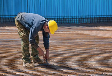 Construction worker installing binding wires clipart