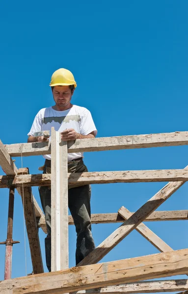 Pracownik budowlany na zajęci przygotowanie deskowania rusztowania — Zdjęcie stockowe