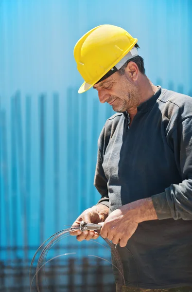 Trabajador de la construcción de alambre de corte con un par de alicates — Foto de Stock